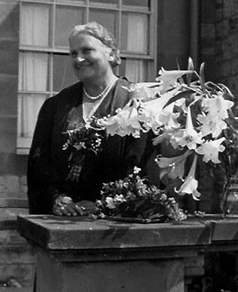 Maria Montessori outside with flowers