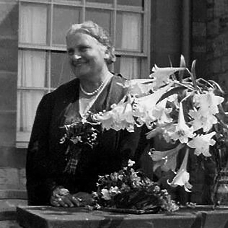 Maria Montessori outside with flowers